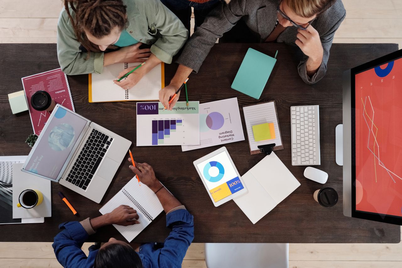 about-us Overhead view of a diverse team collaborating on a project in a modern office setting.